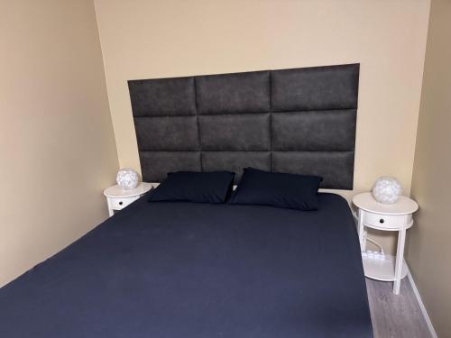 een slaapkamer met een groot bed met twee nachtkastjes bij Warm apart in Kouvola