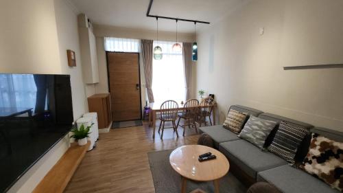 a living room with a couch and a table at Eiko的樓仔厝 台南包棟民宿 in Ching-chung-san-ts'un