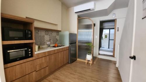 a large kitchen with a sink and a microwave at Eiko的樓仔厝 台南包棟民宿 in Ching-chung-san-ts'un