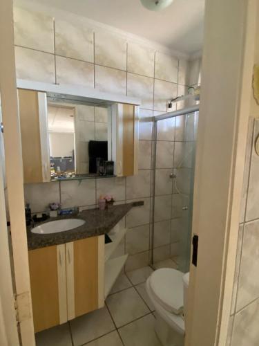 a bathroom with a toilet and a sink and a mirror at Porto das Dunas Apartment in Aquiraz