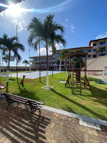a park with a playground with palm trees and a building at Porto das Dunas Apartment in Aquiraz