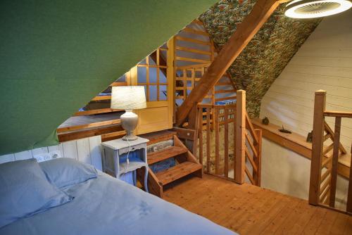 een slaapkamer met een bed en een trap in een huis bij Gîtes calmes écologiques in Saint-Symphorien
