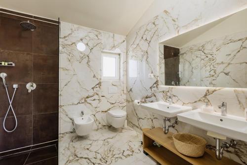 a bathroom with a sink and a toilet and a mirror at Villa Mila with private pool, BBQ and jacuzzi in Strpačići