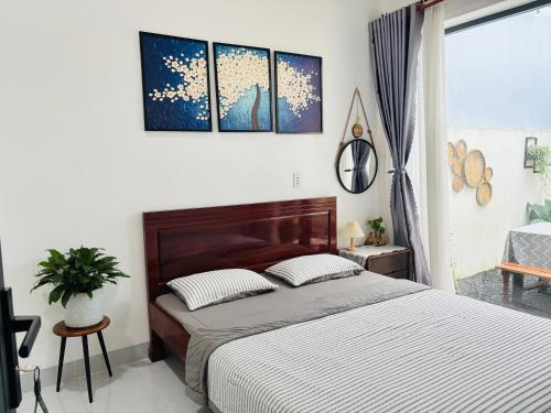 - une chambre avec un grand lit orné de 3 peintures murales dans l'établissement Nhà mình Homestay, à Ấp Thanh Sơn (1)