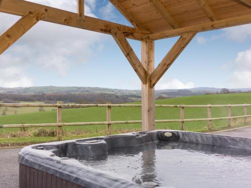 a hot tub with water in it with a view of a field at Y Beudy in Efenechtyd