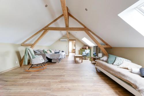 a living room with exposed beams and couches at L'atelier de Théo - Jacuzzi Privé in Chaourse-en-Thiérache