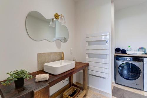 a bathroom with a sink and a washing machine at L'atelier de Théo - Jacuzzi Privé in Chaourse-en-Thiérache