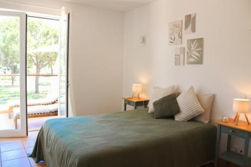 a bedroom with a bed and a sliding glass door at Luxury Apartment in Vila Sol Resort in Quarteira