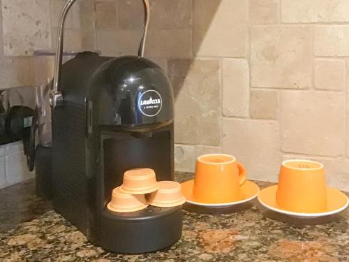 a coffee machine with three cups on a counter at Ebba's Neuk in Beadnell