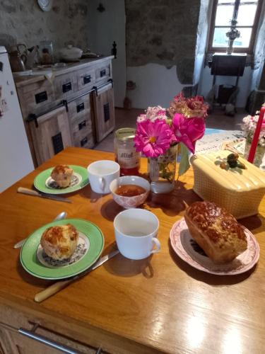 een tafel met borden gebak en bekers erop bij Bed and Cèpes in Busserolles