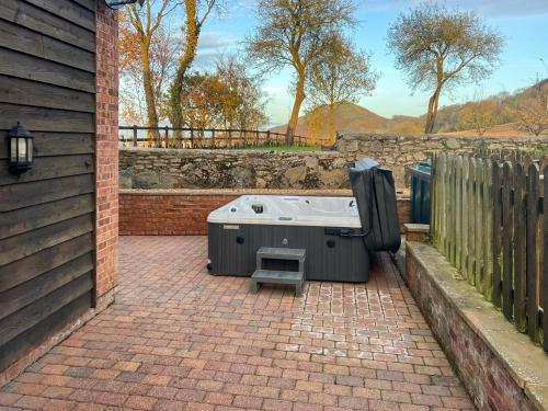 チャーチ・ストレットンにあるUk46589 - Kibbleのホットタブ(フェンスの隣のレンガ造りのパティオに座る)
