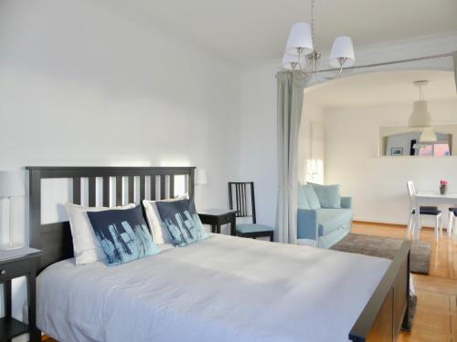 a bedroom with a large white bed with blue pillows at Au Bonheur des Iris in Rolle