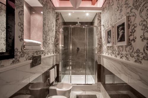 a bathroom with a shower and a toilet at The Inn at the Roman Forum Luxury Collection - The Inn At The Roman Forum in Rome