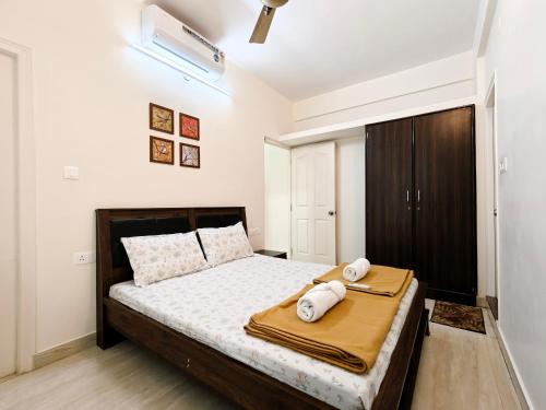 een slaapkamer met een bed met twee handdoeken erop bij Proximus - Boutique Hotel Apartments in Bangalore