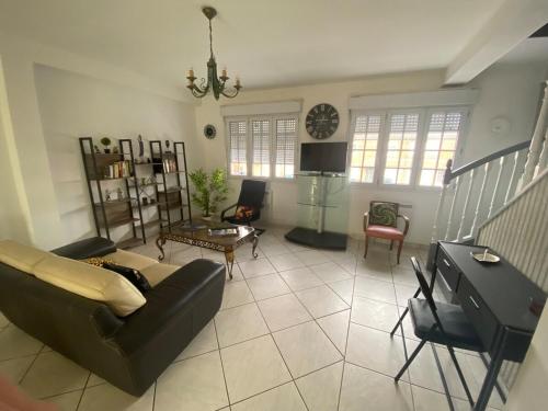 Una sala de estar con un sofá y un televisor. en L'Hippodrome d'Arras - Appartement 3 chambres, en Arras