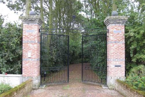 an entrance to a gate with a brick pillar at Boerderijlodge Kamperland in Kamperland