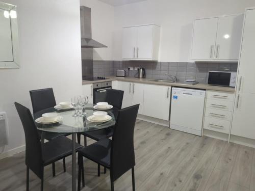 a kitchen with a table and chairs in a kitchen at Newcastle Executive Stays in Newcastle upon Tyne