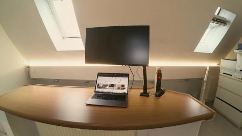 un ordinateur portable posé sur une table avec une lampe dans l'établissement Ferienwohnung zwischen Nürnberg und Seenland, à Weißenburg in Bayern