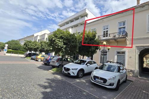 two cars parked in a parking lot next to a building at Lumina Wellness Apartman in Sátoraljaújhely