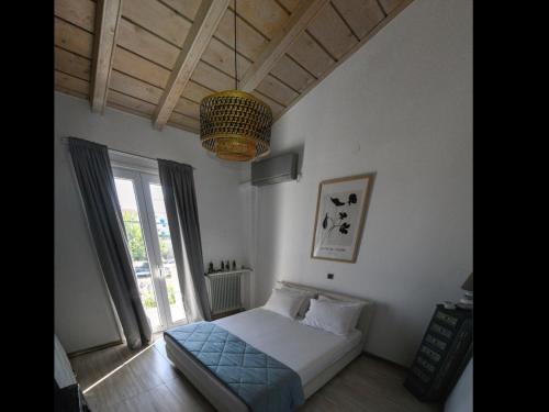 a bedroom with a bed and a large window at Pipina's Beach Apartment in Fanari