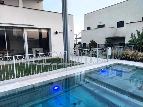 una piscina con luci blu di fronte a un edificio di Tzafona Villa, Katzrin a Qatzrin