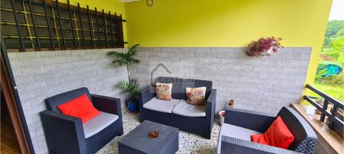 eine Terrasse mit 2 Stühlen, einem Sofa und einem Tisch in der Unterkunft Villa Teresa in Cangas de Onís