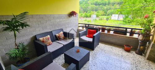 einen Balkon mit 2 Stühlen, einem Sofa und einem Fenster in der Unterkunft Villa Teresa in Cangas de Onís