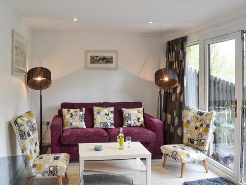 a living room with a purple couch and a table at Gracelands in Uny Lelant