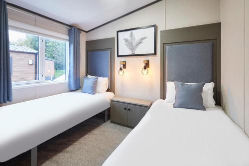 two beds in a room with two windows at Sandy Lane 20 in York