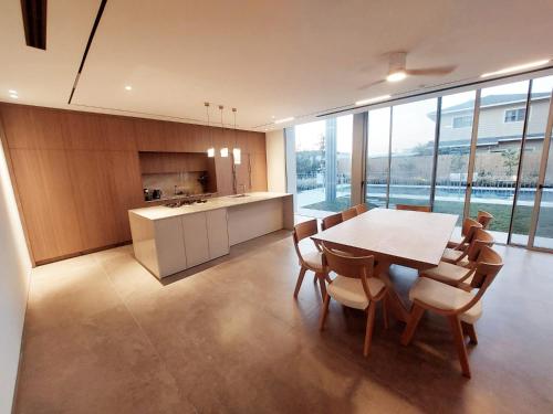 una cucina e una sala da pranzo con tavolo e sedie di Tzafona Villa, Katzrin a Qatzrin