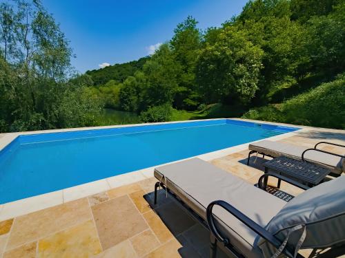 a swimming pool with two chairs and a table at Domeniul Caprioara in Căprioara