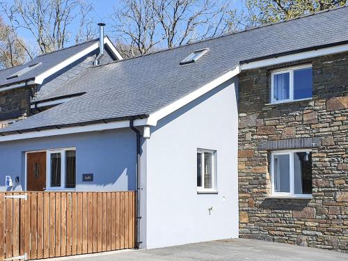 a white garage door on a stone house at Stabl-Oh4 in Dihewid