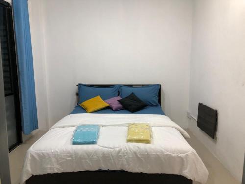 a bed with colorful pillows on it in a room at DEN NEST Guest House Krabi in Ban Khlong Chi Lat
