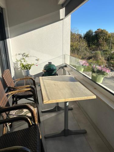 a table and chairs on a balcony with a window at Mira Mare Apartments in Kryvyi Rih