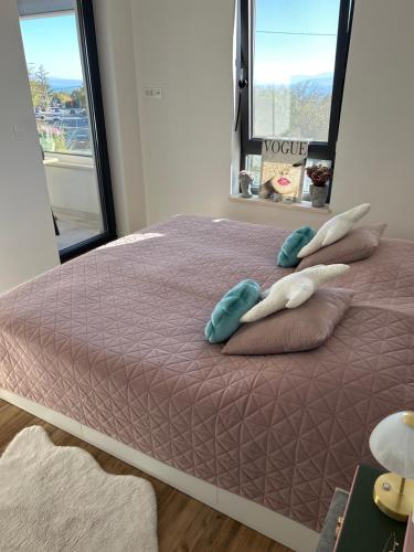 a bedroom with a bed with pillows and a window at Mira Mare Apartments in Kryvyi Rih