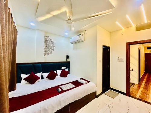 Un dormitorio con una cama grande con almohadas rojas. en Hotel Shree, en Ujjain
