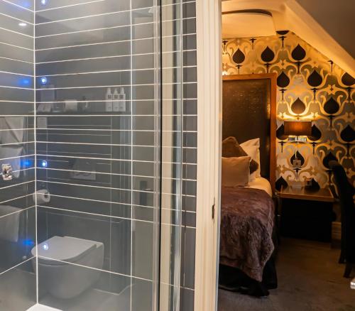 a glass shower in a bedroom with a bed at The Cranleigh Boutique in Bowness-on-Windermere