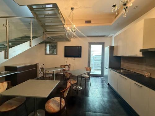 a kitchen with tables and chairs and a tv at Sweet Dreams Residence in Brugine