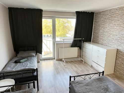 a small room with two beds and a window at Monteurunterkunft in Raunheim in Raunheim