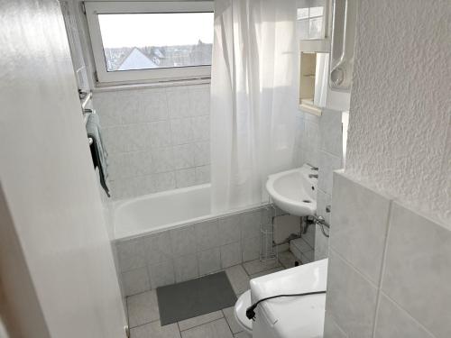 a white bathroom with a toilet and a sink at Monteurunterkunft in Raunheim in Raunheim