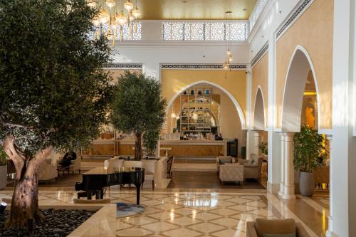 a lobby with tables and chairs in a building at Rixos Bab Al Bahr - Ultra All Inclusive in Ras al Khaimah