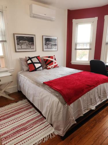 een slaapkamer met een groot bed met een rode deken bij Market Haven in Wilmington