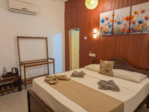 a bedroom with a bed with bows on it at Choona Lodge 'view of sigiriya & pidurangala with sunrise' in Sigiriya