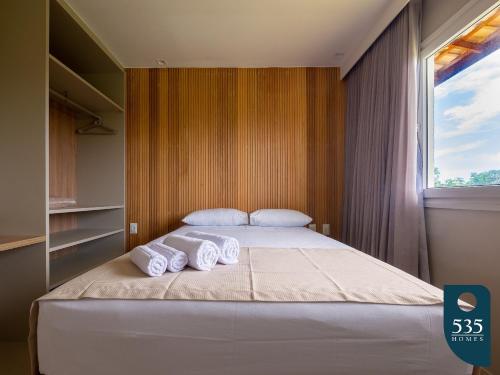 a bedroom with a bed with three towels on it at Praia do Forte 2 bedrooms Complete and Comfortable in Mata de Sao Joao
