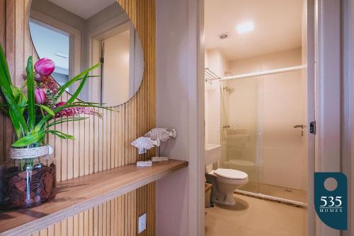a bathroom with a toilet and a mirror at Praia do Forte 2 bedrooms Complete and Comfortable in Mata de Sao Joao