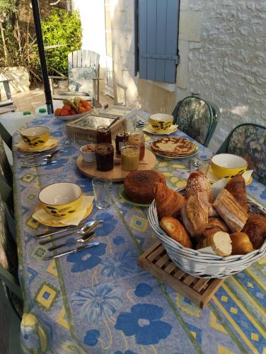un tavolo con un mucchio di pane e dolci sopra di au petit chai a Brives-sur-Charente