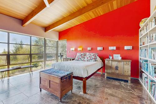 a bedroom with a bed and a red wall at Rackliff Island Hideaway in Spruce Head