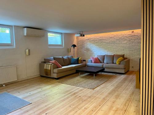 a living room with two couches and a brick wall at Stenkällan - snabbuss 5 in Malmö
