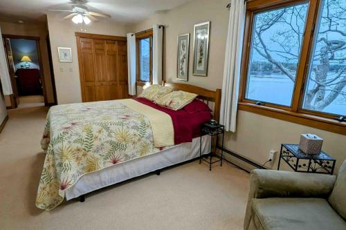 a bedroom with a bed and a couch and windows at High View in Dyer Cove