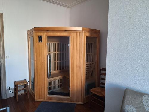 a wooden cabinet with a bird cage in a room at Petite maison proche cathédrale centre 3 pers in Toul